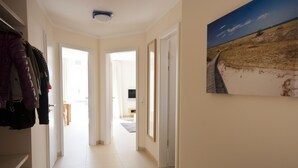 A hallway with a coat rack, a framed picture on the wall, and a door leading to another room. - Bright apartment with elevator, wellness area, fitness, sauna, families, WiFi (Niendorf)