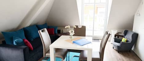 A modern loft apartment with a dining area, a sofa, and a chair.