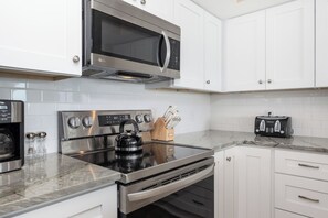 A modern kitchen with stainless steel appliances, including a microwave, oven, and coffee maker.