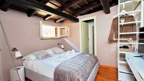 Een slaapkamer met een bed, nachtkastjes, een kledingkast en een spiegel.