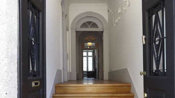 A staircase with wooden steps leading to an arched doorway. - Pensão Favorita (Porto)