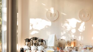 A breakfast buffet setup with coffee makers, teapots, and various food items. - Pensão Favorita (Porto)