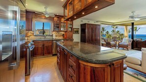 A spacious kitchen with wooden cabinets, stainless steel appliances, and a large island.