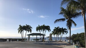 A beachside area with a gazebo, palm trees, and a stone structure. - *Snowbirds Paradise* (Marathon)