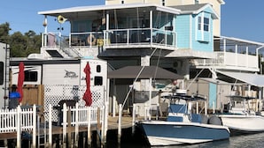 A waterfront property with a multi-level house, docked boats, and a covered outdoor area. - *Snowbirds Paradise* (Marathon)