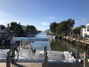 Un puerto deportivo con barcos amarrados a lo largo de un canal estrecho, rodeado de edificios residenciales y árboles.