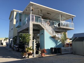 Un edificio de varios pisos con balcón, escaleras y garaje.