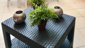 A patio area with white wicker furniture, potted plants, and a woven table. - Chic 'n Charme Trastevere Terrace (Roma)
