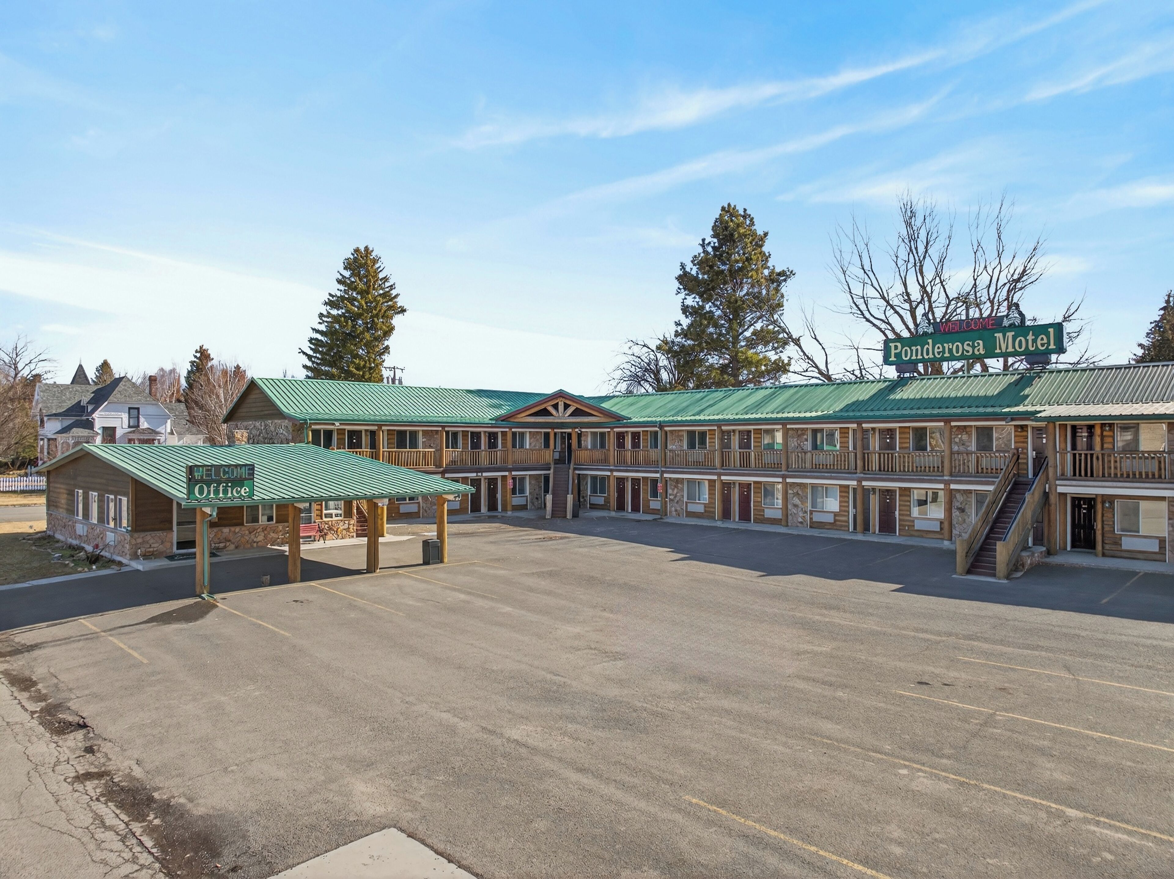 A motel with multiple rooms, a welcome office, and a parking lot.