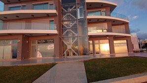 A modern multi-story building with a glass facade, a central staircase, and a flat roof. - Rhodes Skyline Suites (Rhodes)