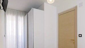 A room with a wooden floor, a white door, and a light fixture on the ceiling. - Apartment Rita (Split)