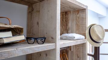 A wooden shelf with books, glasses, and a hat.