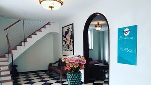A dining area with a wooden table, a pineapple vase, and a checkered floor.
