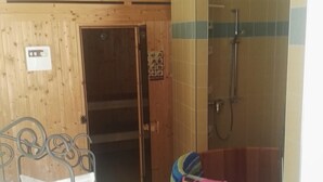 A bathroom with a wooden wall, a shower area, and a bathtub. - Kurparkstübl Bad Schandau (Bad Schandau)