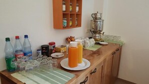 A kitchen counter with various items including bottles, glasses, a pitcher of orange juice, and a coffee pot. - Kurparkstübl Bad Schandau (Bad Schandau)