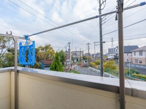Ein Balkon mit Blick auf einen Bahnübergang und umliegende Gebäude.