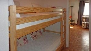 A bunk bed in a room with a tiled floor and a lamp in the corner. - 50m from ski slopes, 3rd floor, balcony, 30m², Les Orres (Les Orres)