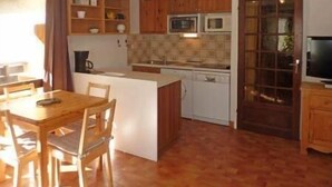 A compact kitchen with wooden cabinets, a microwave, and a dishwasher. - 50m from ski slopes, 3rd floor, balcony, 30m², Les Orres (Les Orres)