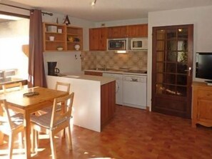A compact kitchen with wooden cabinets, a microwave, and a dishwasher. - 50m from ski slopes, 3rd floor, balcony, 30m², Les Orres (Les Orres)