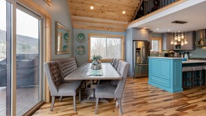 Una cocina moderna con suelo de madera, un área de comedor con banco y una isla azul.