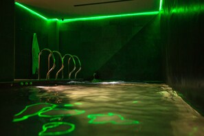 Relax by the pool surrounded by sleek walls and a reflective floor.