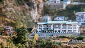 Un immeuble à plusieurs étages, doté d’une architecture traditionnelle, situé sur une colline et offrant une vue sur le paysage environnant.