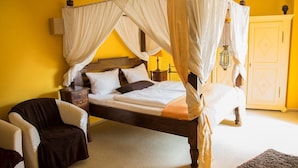 A four-poster canopy bed with white bedding, a wooden headboard, and a nightstand with a lamp. - Villa ZOE St Wendel (Sankt Wendel)