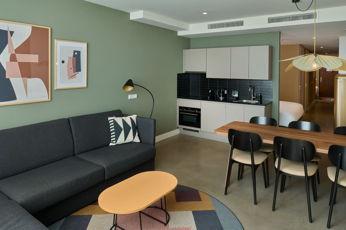 Una sala de estar moderna con un sofá, una mesa de centro y un comedor con sillas y una mesa de madera.