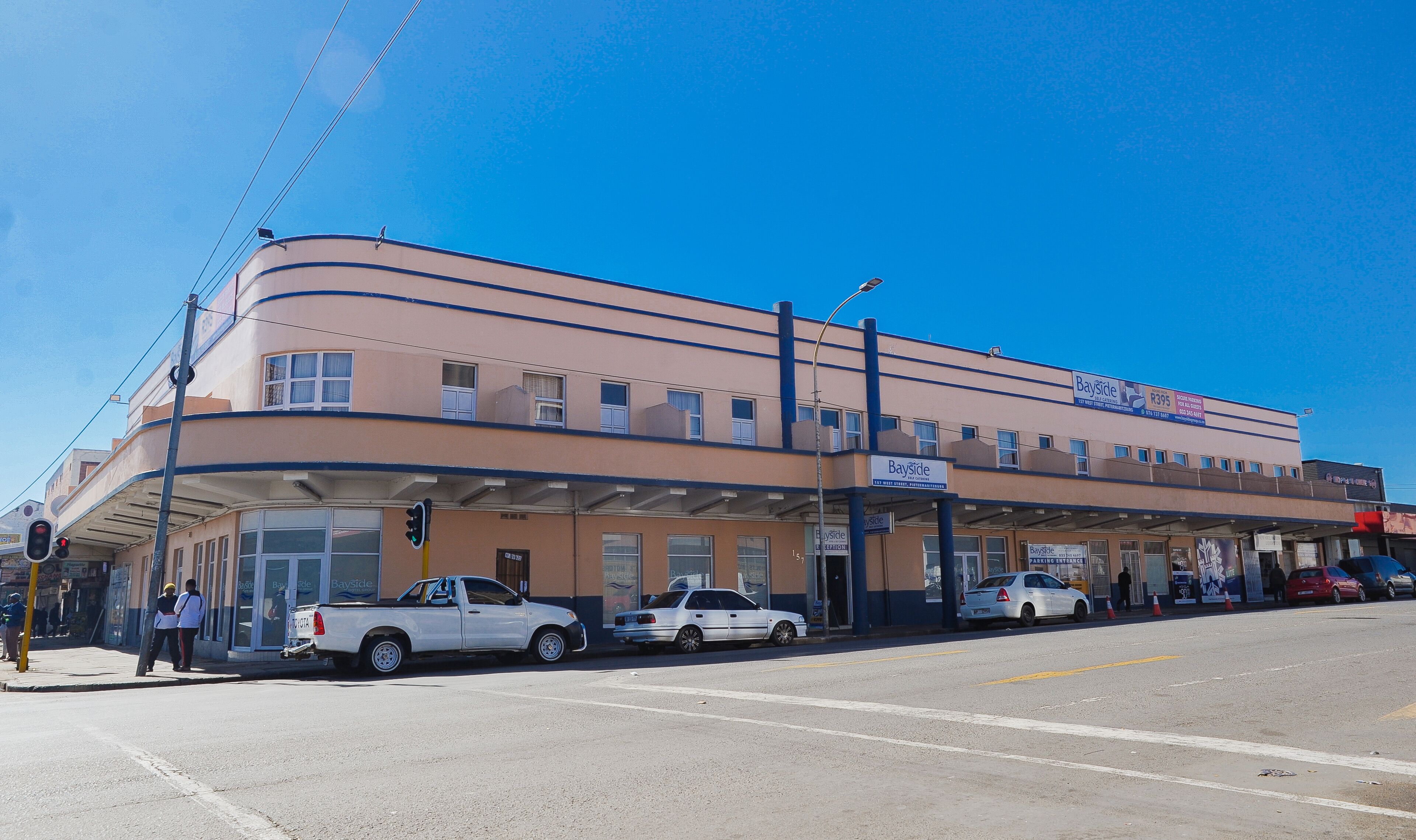 A Bayside building with a flat facade, multiple windows, and a covered parking area.