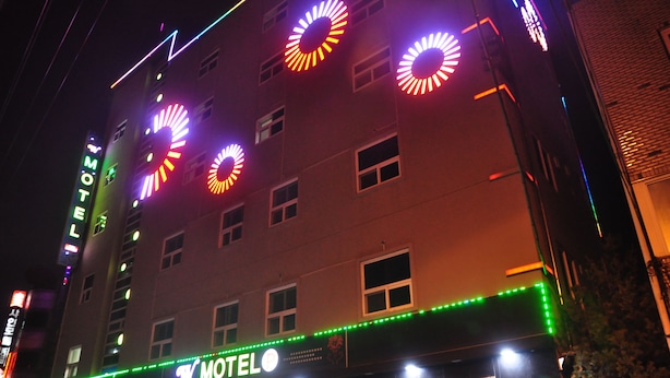 A building with a sign that reads "MOTEL" and multiple circular light decorations. - W Motel (Andong)