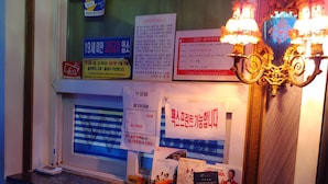 A reception desk with various informational posters, a scale, and a decorative lamp. - W Motel (Andong)