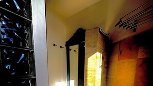 Una habitación con suelo de baldosas, puerta de madera y ventana que deja entrar luz natural.