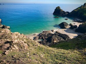 A coastal landscape with rocky terrain and a beach. - Coastal cottage - sea views on coast path, amazing local beaches, The Lizard (Lizard)