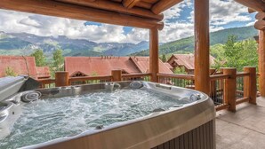 Un jacuzzi en una terraza de madera con vistas a la montaña.