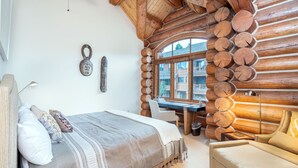 A log cabin bedroom with a bed, a desk, and a chair. - Beautiful Ski-In/Ski-Out Log Townhome with Exceptional Views (Mountain Village)