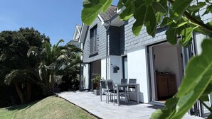 Ett modernt hus med en uteplats, ett matområde och ett garage.