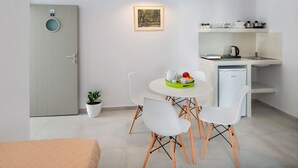 Una cocina moderna con electrodomésticos blancos, una mesa de comedor con sillas y una pequeña planta en maceta.