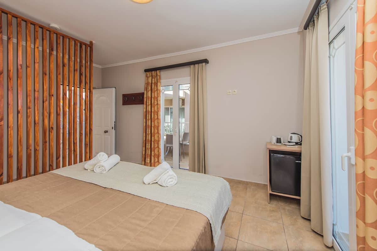 Habitación de hotel con cama, escritorio y una pequeña cocina.