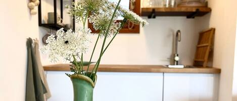 Two green ceramic vases with scalloped designs on a white table.