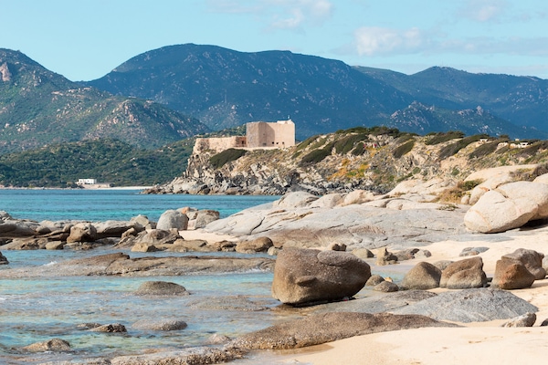 Una playa cerca, arena blanca, sombrillas, toallas de playa