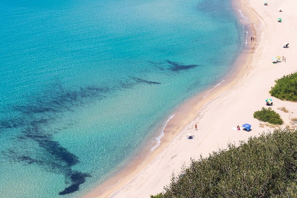 Pantai di sekitar, pasir putih, payung pantai, dan handuk pantai