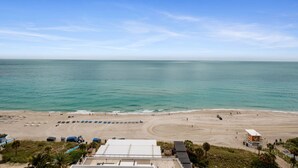 Una spiaggia con una torretta di salvataggio, ombrelloni e una vista libera sull'oceano.