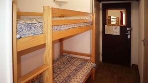 A bunk bed with patterned bedding, a door with a mirror, and a hallway with wooden flooring. - 1st floor, balcony, 32m², Les Orres (Les Orres)