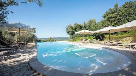 Una piscina al aire libre de temporada, sombrillas