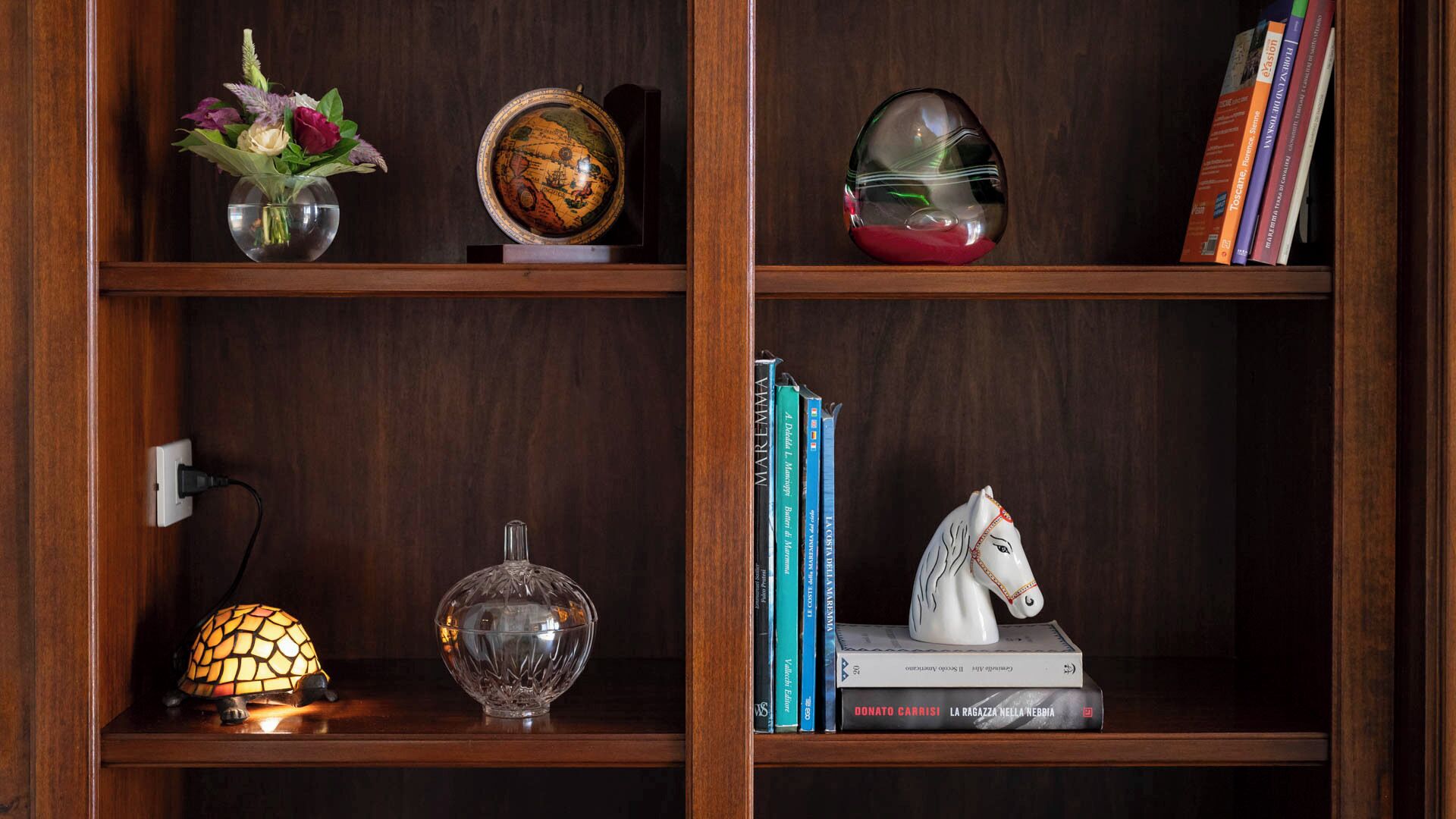 Una estantería de madera con objetos decorativos y libros.