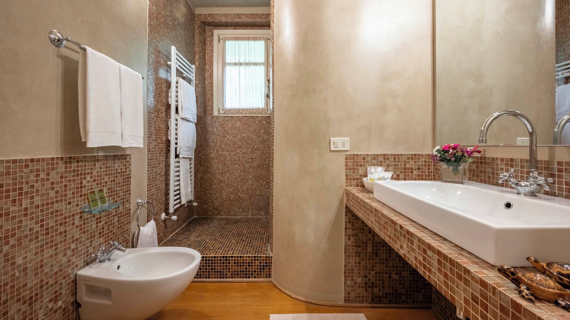A bathroom with a bidet, a bathtub, and a sink.