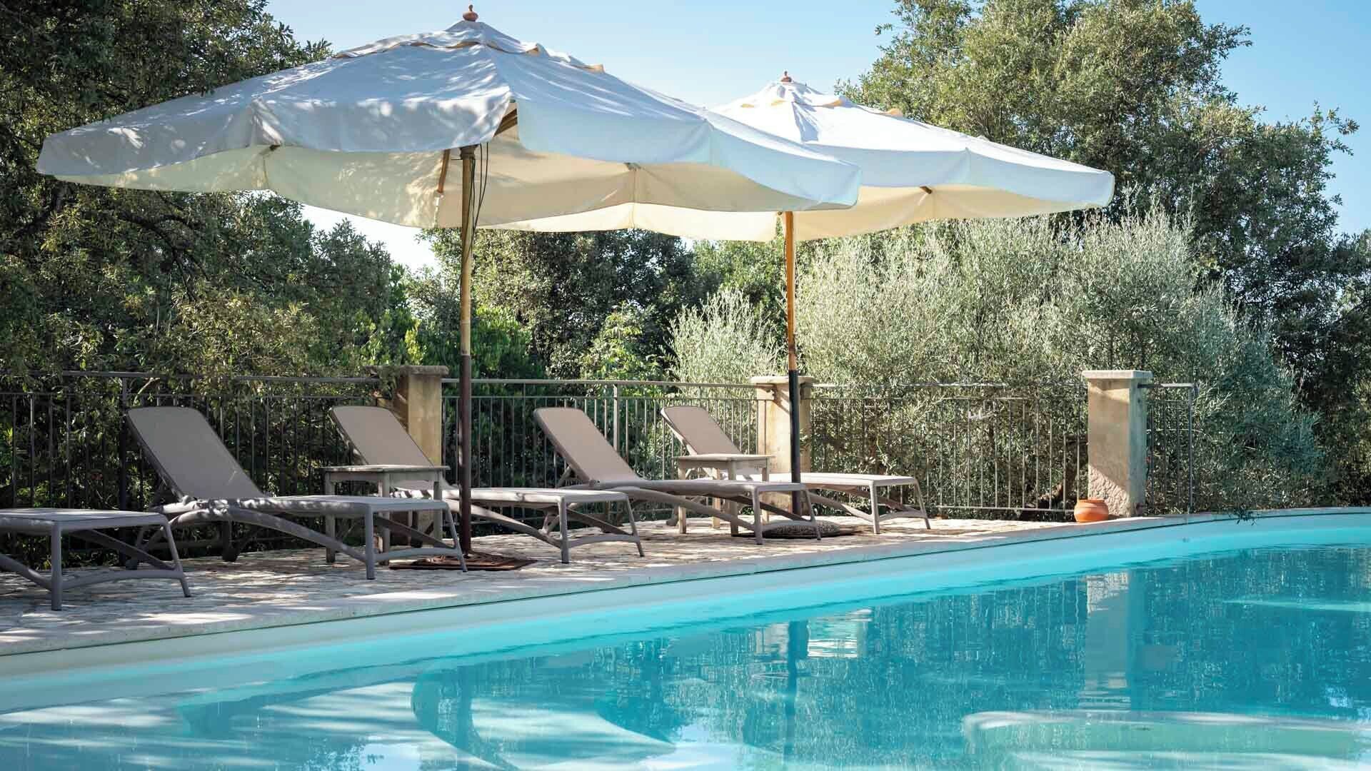 A poolside area with lounge chairs and umbrellas.