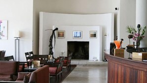 A spacious lobby with a fireplace, seating area, and artwork on the walls.