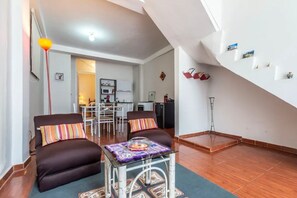 A modern living room with a sofa set, a coffee table, and a dining area with a table and chairs.