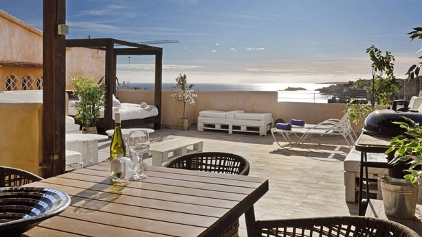 A rooftop terrace with a bed, lounge chairs, and a table with wine glasses. - Villa Can Moya (Palma)